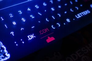 Glowing keyboard with ".com" highlighted in red.